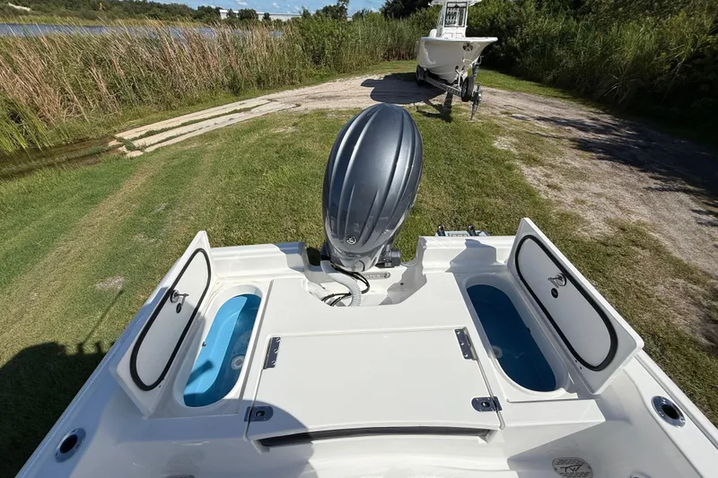 Slide: The Image of 2026 Tidewater 2210 Carolina Bay boat with open storage compartments and outboard motor. - 25