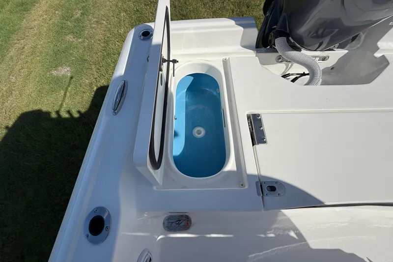 Slide: The Image of Livewell on 2026 Tidewater 2210 Carolina Bay boat, open lid, blue interior. - 26