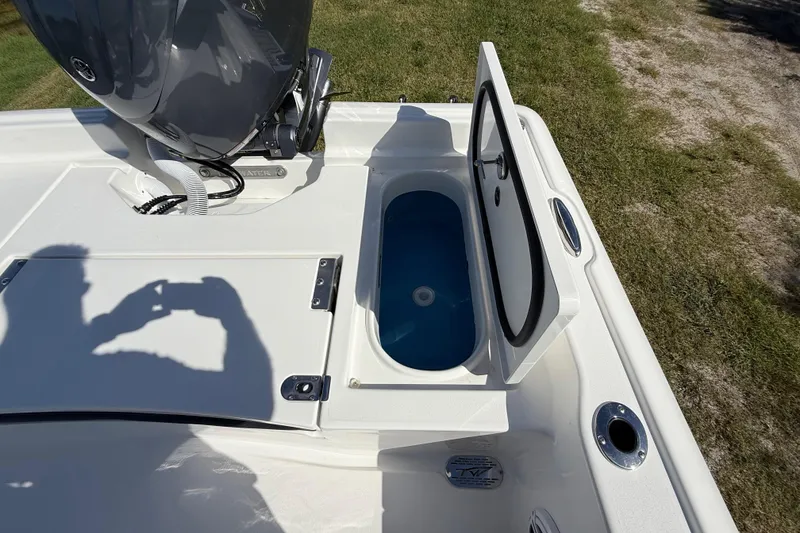 Slide: The Image of 2026 Tidewater 2210 Carolina Bay boat with open storage compartment and engine detail. - 27
