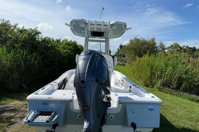 Slide: The Image of 2026 Tidewater 2210 Carolina Bay boat with Yamaha engine, parked on grassy area. - 5