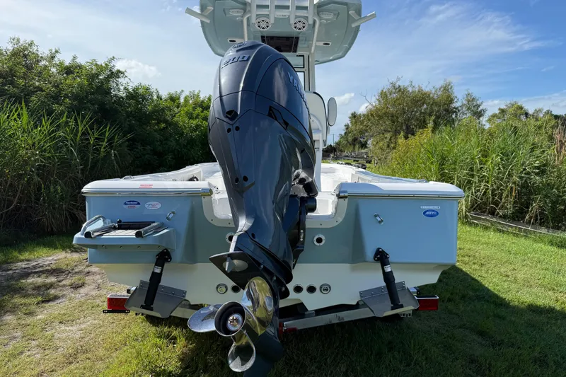 Slide: The Image of 2026 Tidewater 2210 Carolina Bay boat with powerful outboard motor, parked on grassy area. - 6