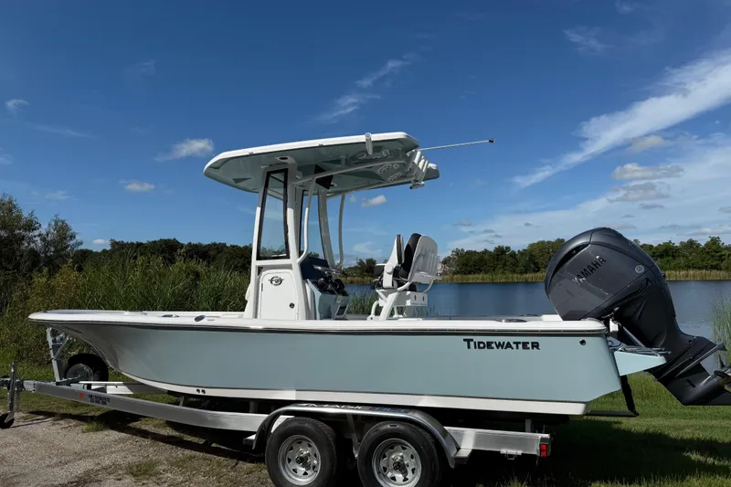 Slide: The Image of 2026 Tidewater 2210 Carolina Bay boat on trailer by a lake under clear blue sky. - 7