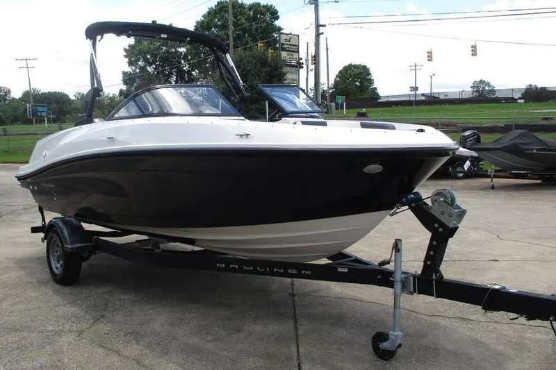 Slide: The Image of 2022 Bayliner VR5 Bowrider I/O on trailer, black and white exterior, parked outdoors. - 6