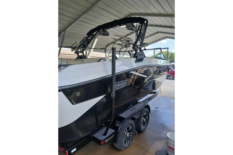 Slide: The Image of 2023 Heyday H22 boat on trailer under shelter, featuring sleek black and white design. - 1