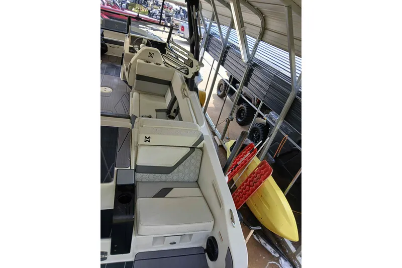 Slide: The Image of 2023 Heyday H22 boat interior with modern seating and storage, under a covered dock. - 10
