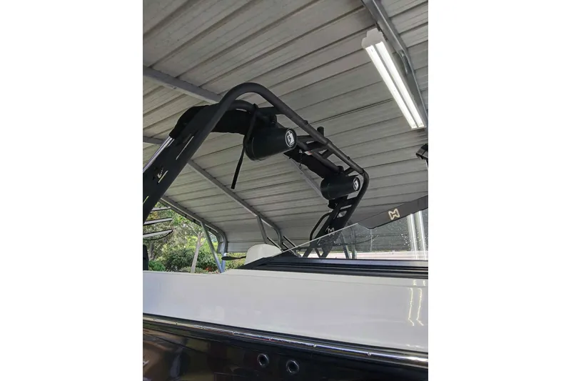 Slide: The Image of 2023 Heyday H22 boat with a sleek black and white design under a metal roof. - 5