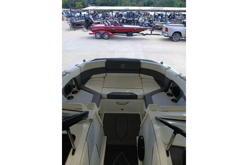 Slide: The Image of 2023 Heyday H22 boat interior with seating, parked near a red boat and truck. - 6