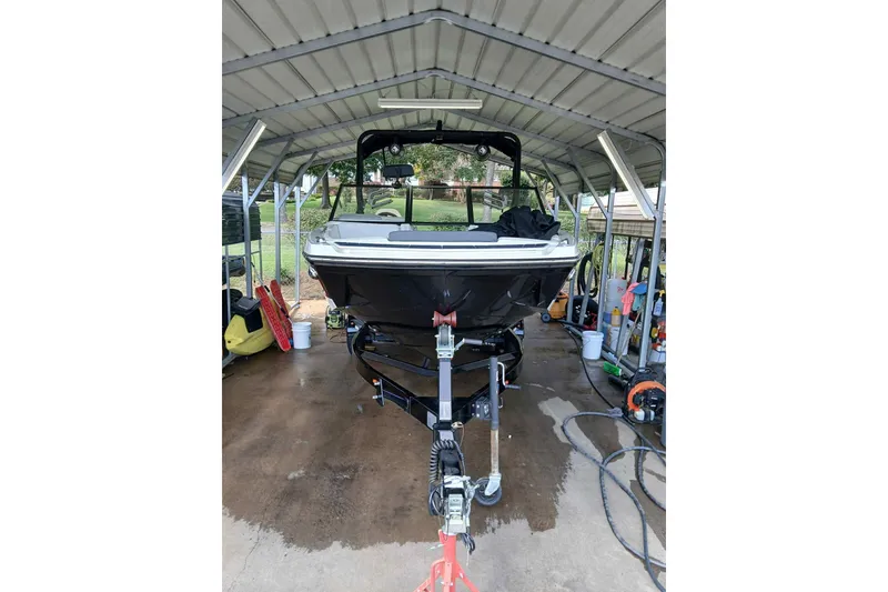 Slide: The Image of 2023 Heyday H22 boat under a metal canopy, parked on a trailer. - 3