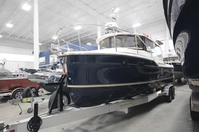 The Image of 2026 Ranger Tugs R-25 boat on trailer in indoor showroom. - 0