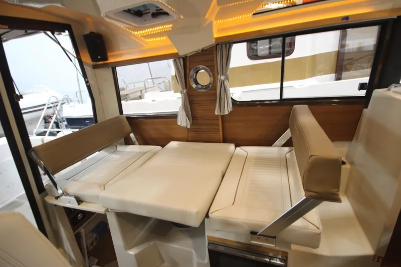 Slide: The Image of 2026 Ranger Tugs R-25 interior with convertible seating and modern lighting. - 22