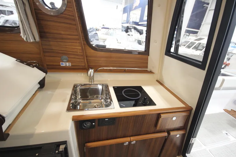 Slide: The Image of Compact kitchen area in 2026 Ranger Tugs R-25 boat with sink and stove. - 28