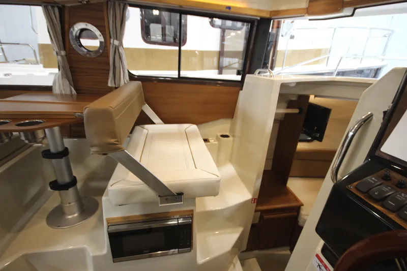 Slide: The Image of Interior of 2026 Ranger Tugs R-25 boat, featuring seating and navigation area. - 29