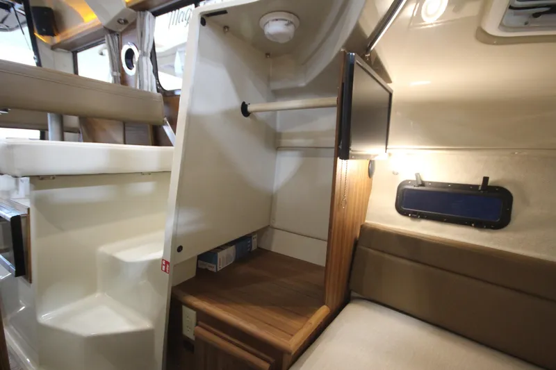 Slide: The Image of 2026 Ranger Tugs R-25 interior cabin with seating, storage, and window. - 34