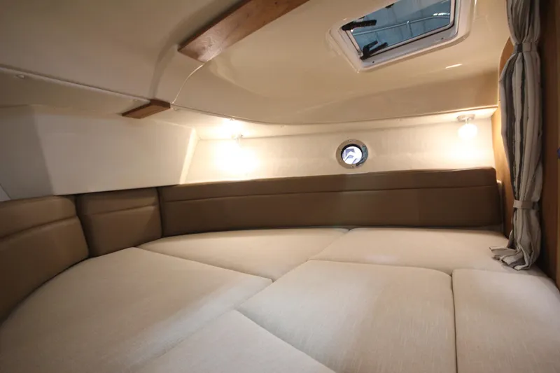 Slide: The Image of 2026 Ranger Tugs R-25 cabin interior with cozy seating and ambient lighting. - 35
