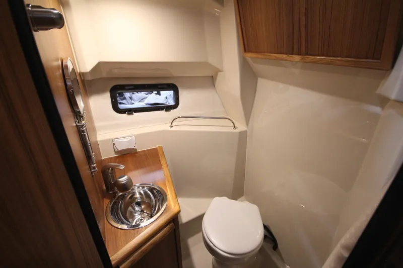 Slide: The Image of 2026 Ranger Tugs R-25 boat bathroom with sink, toilet, and window. - 39