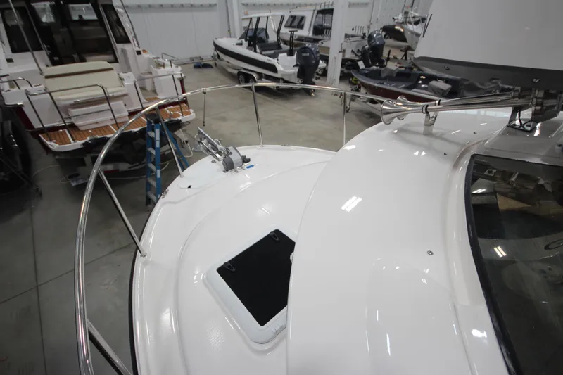 Slide: The Image of 2026 Ranger Tugs R-25 boat in showroom, showcasing sleek deck design and railing. - 41