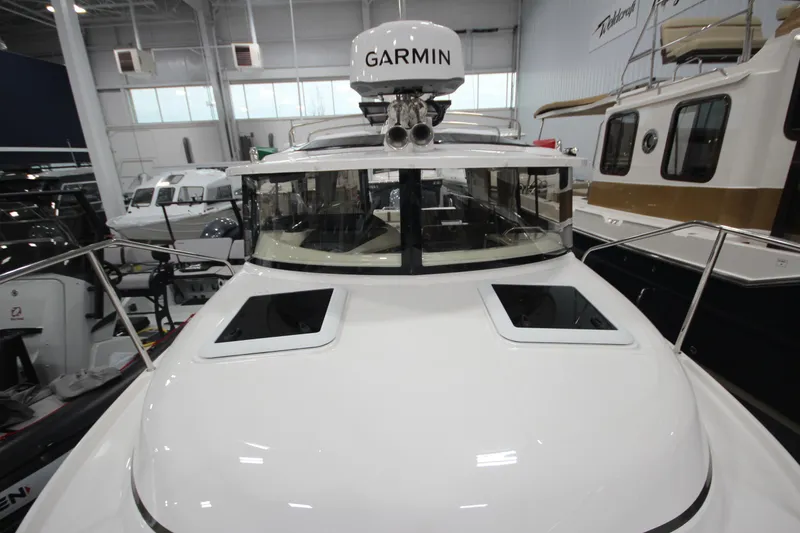 Slide: The Image of 2026 Ranger Tugs R-25 boat with Garmin equipment in a showroom. - 43
