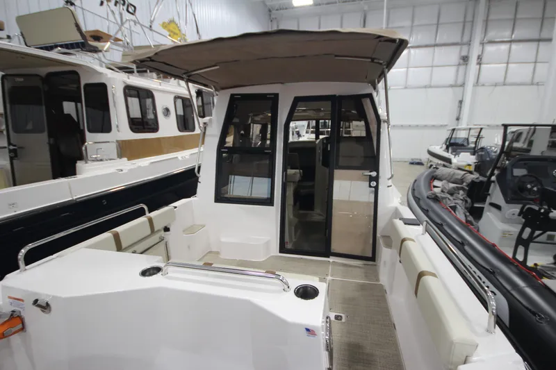 Slide: The Image of 2026 Ranger Tugs R-25 boat interior with seating and canopy in a showroom. - 7