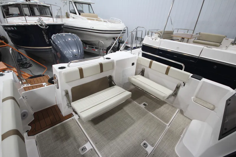 Slide: The Image of 2026 Ranger Tugs R-25 boat interior with foldable seating in a showroom. - 9