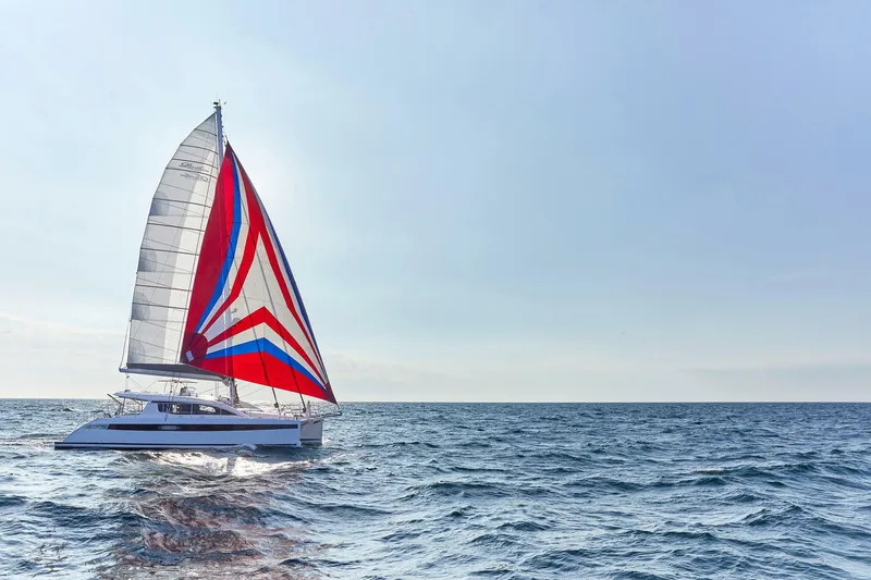 Slide: The Image of Red Privilege Signature 510 catamaran sailing on the sea, 2025 model. - 4