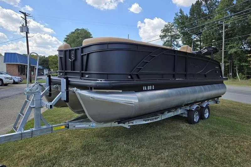 Slide: The Image of 2025 Godfrey Monaco 235 DFL iMPACT pontoon boat on trailer, parked on grass. - 1