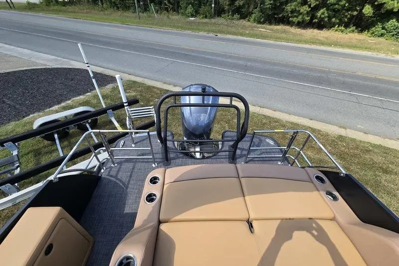 Slide: The Image of 2025 Godfrey Monaco 235 DFL iMPACT boat with tan seating and outboard motor. - 10