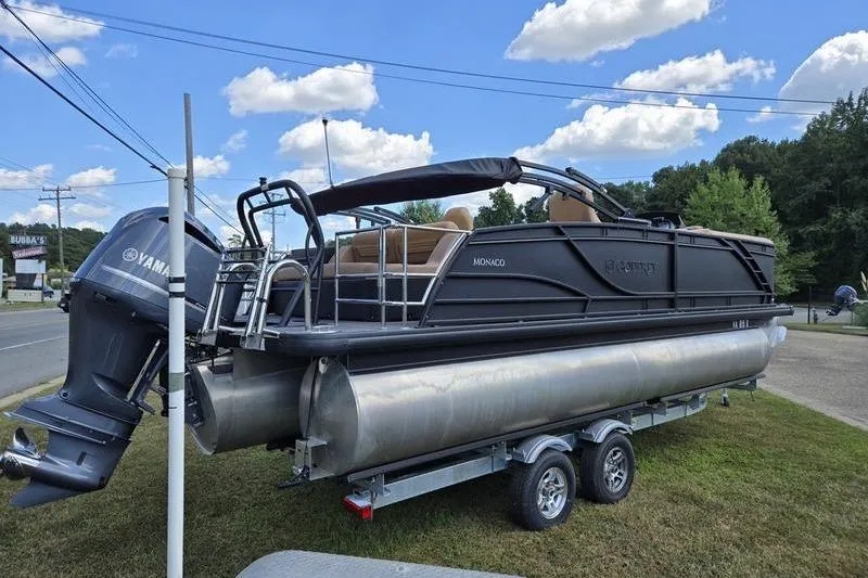 Slide: The Image of 2025 Godfrey Monaco 235 DFL iMPACT pontoon boat on trailer, parked outdoors. - 19