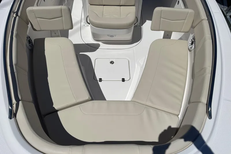 Slide: The Image of 2026 Robalo R232 Explorer boat interior with beige seating and storage compartment. - 13