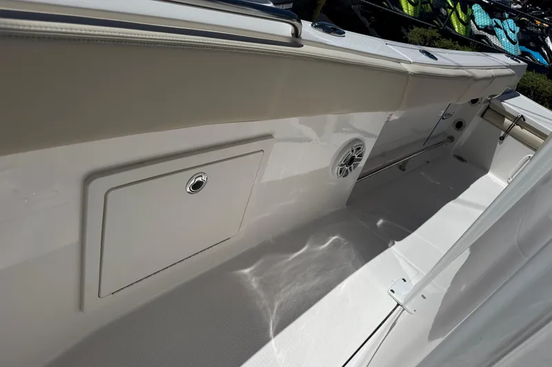 Slide: The Image of 2026 Robalo R232 Explorer boat interior with storage compartment and speaker. - 18