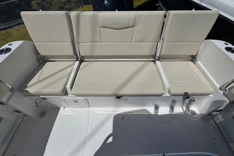 Slide: The Image of Robalo R232 Explorer 2026 boat seating area with beige cushions and cup holders. - 23