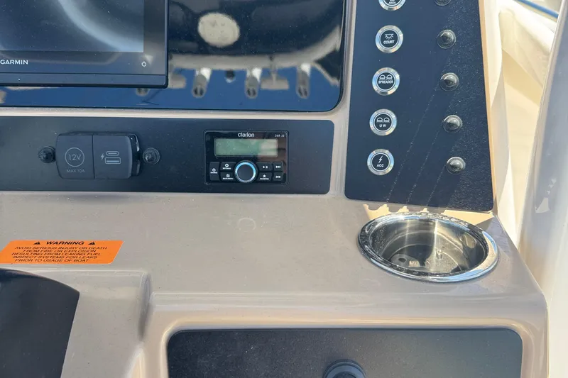 Slide: The Image of Control panel of 2026 Robalo R232 Explorer boat with switches and cup holder. - 24