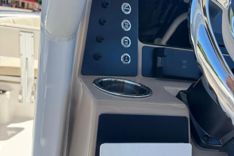 Slide: The Image of 2026 Robalo R232 Explorer boat dashboard with controls and cup holder. - 26