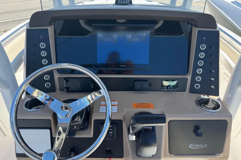 Slide: The Image of 2026 Robalo R232 Explorer boat dashboard with steering wheel and control panel. - 8