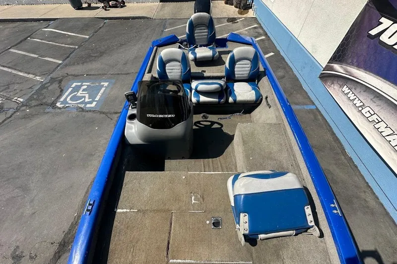 Slide: The Image of 2005 Bass Tracker Pro Team 175 boat with blue and gray seating, parked on pavement. - 21
