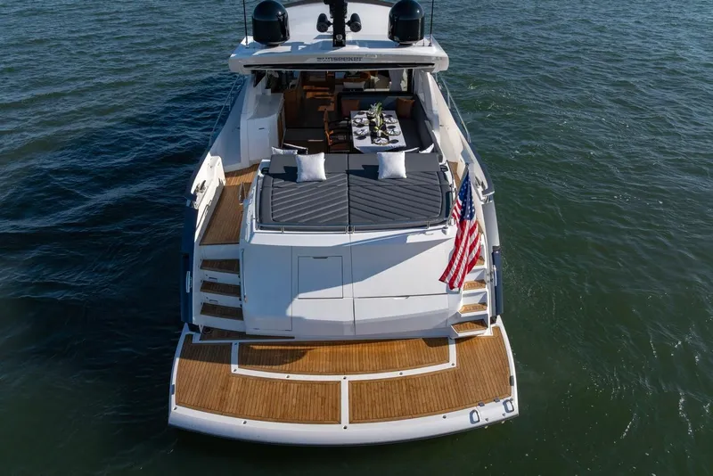 Slide: The Image of 2020 Sunseeker Predator 74 yacht with elegant deck and American flag on open water. - 10