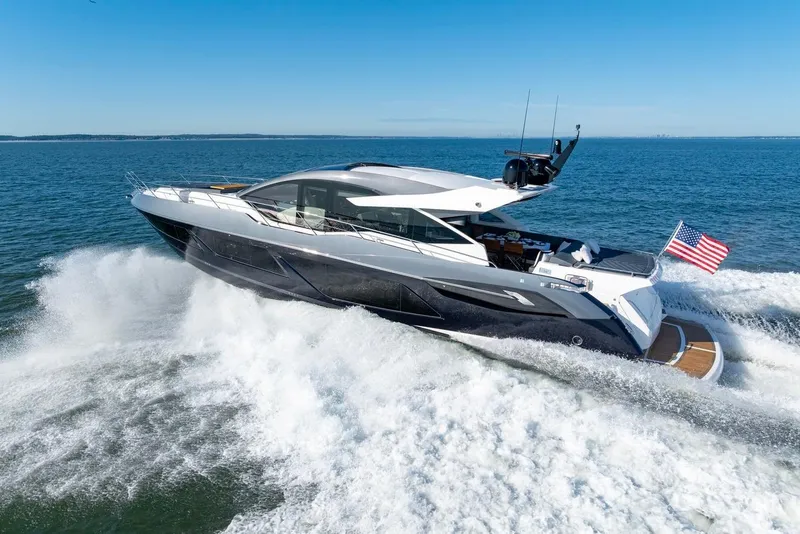 Slide: The Image of 2020 Sunseeker Predator 74 yacht cruising on open water with American flag. - 17