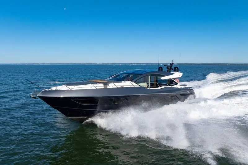 Slide: The Image of 2020 Sunseeker Predator 74 yacht cruising on open water under clear blue sky. - 18