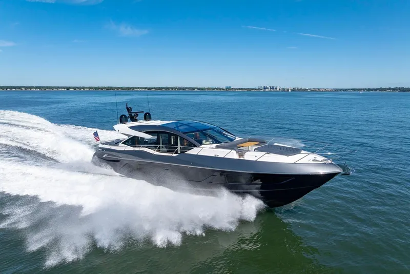 Slide: The Image of 2020 Sunseeker Predator 74 yacht cruising on open water under clear blue skies. - 24