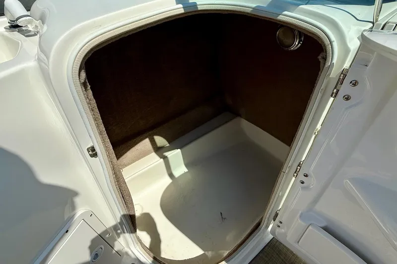 Slide: The Image of 2018 NauticStar 223 DC boat storage compartment with open door, showing interior space. - 12