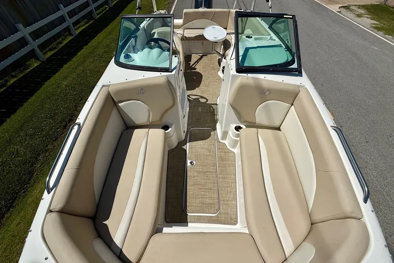 Slide: The Image of 2018 NauticStar 223 DC boat interior with beige seating and open deck layout. - 15