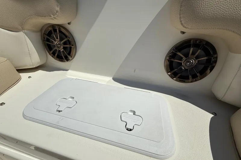 Slide: The Image of 2018 NauticStar 223 DC boat interior with speakers and storage compartment. - 18