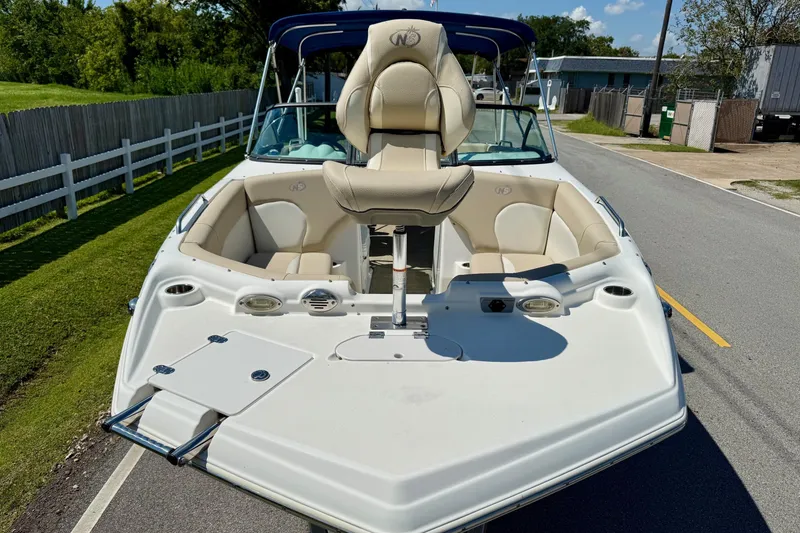 Slide: The Image of 2018 NauticStar 223 DC boat with beige seating and blue canopy on a sunny day. - 6