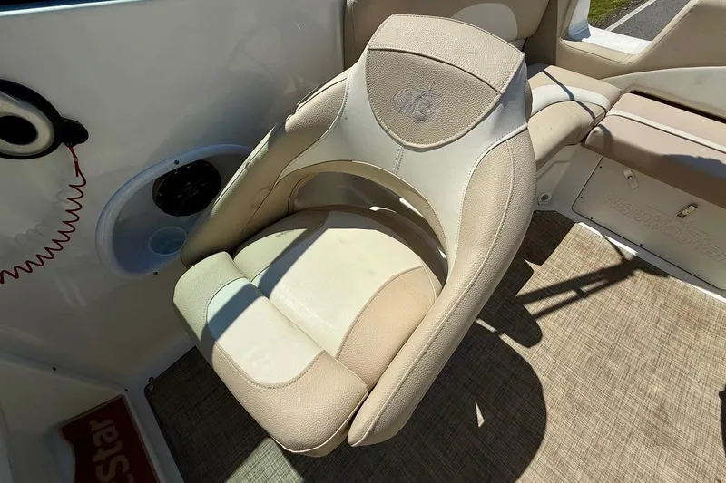 Slide: The Image of Beige captain's chair on 2018 NauticStar 223 DC boat, featuring comfortable design and cup holder. - 9
