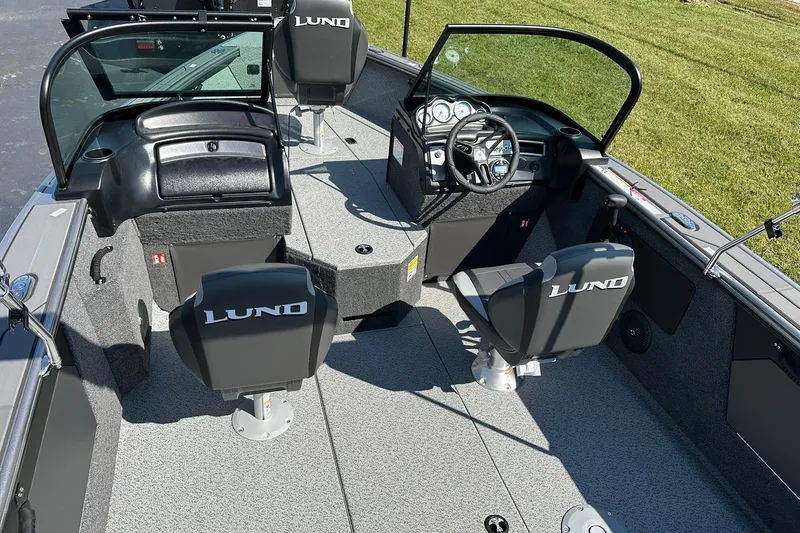 Slide: The Image of 2026 Lund 1875 Fisherman boat interior with steering wheel and seating. - 12