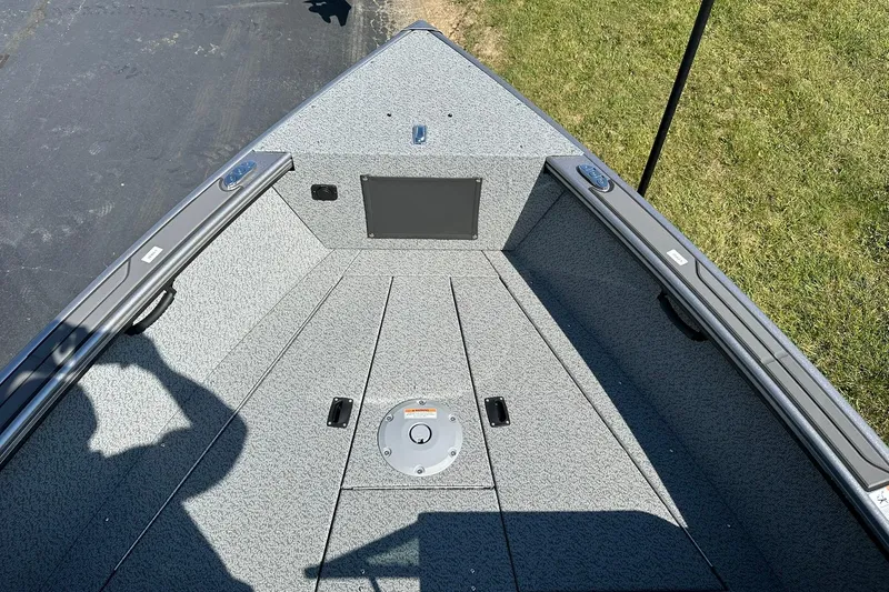 Slide: The Image of 2026 Lund 1875 Fisherman boat interior with gray textured flooring and storage compartments. - 20