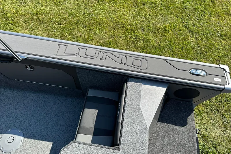 Slide: The Image of 2026 Lund 1875 Fisherman boat interior with logo, gray seating, and carpeted flooring. - 30