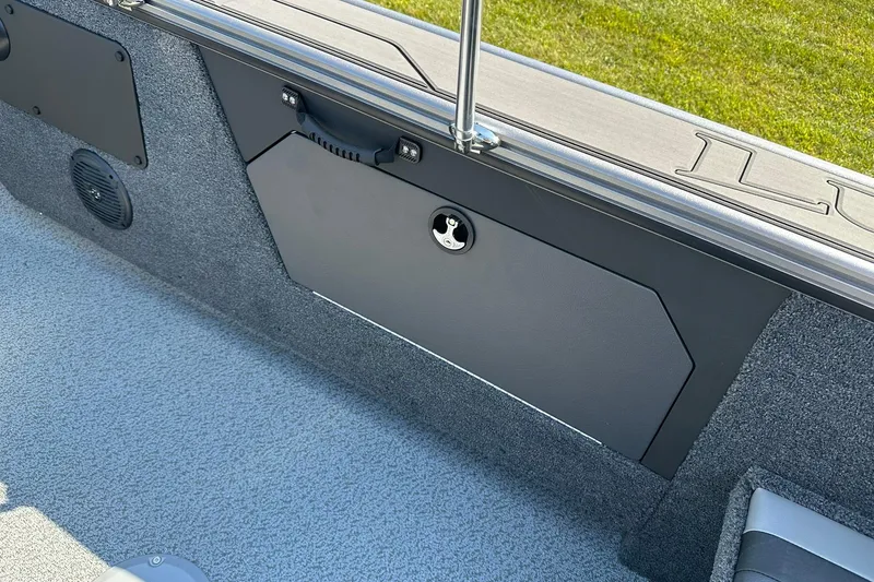 Slide: The Image of 2026 Lund 1875 Fisherman boat interior with storage compartment and speaker. - 33