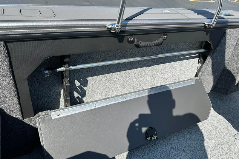Slide: The Image of 2026 Lund 1875 Fisherman boat interior storage compartment with handle and shadow. - 35