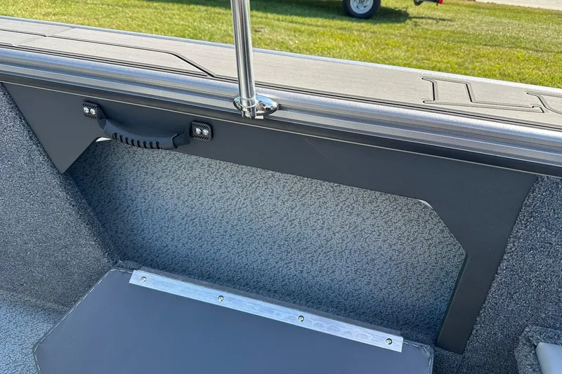 Slide: The Image of 2026 Lund 1875 Fisherman boat interior with handle and textured paneling. - 36