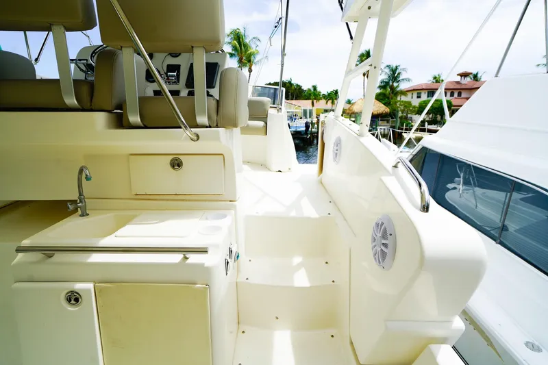 Slide: The Image of 2002 Silverton 352 Motor Yacht deck with seating, sink, and marina view. - 12